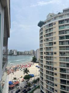 a view of a beach and a large building at Luxor Oceanfront Suite Smart Apartment Beachfront Superb 9,2 in Guarujá