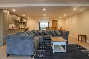 a living room with a blue couch and a table at Bears Court Barn 8 in Cheltenham +14 photos