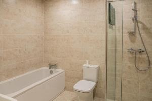 a bathroom with a toilet and a glass shower at Bears Court Barn 7 in Cheltenham +15 photos