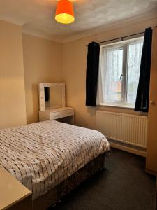 een slaapkamer met een bed en een raam bij JXB HOMES - Lovely and spacious rooms in Kent +29 foto's