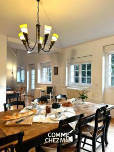 a dining room with a table and chairs and a chandelier at Le Chatelier in Louvemont