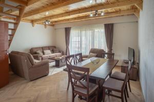 a living room with a table and chairs and a couch at Vila Malineta in Žabljak