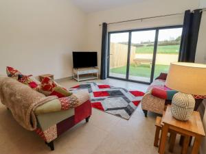 a living room with a couch and a tv at Bears Court Barn 2 in Cheltenham