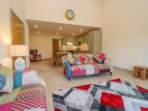 a living room with a couch and a clock on the wall at Bears Court Barn 2 in Cheltenham