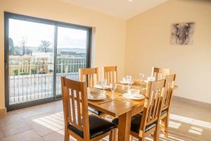 a dining room with a wooden table and chairs at Bears Court Barn 5 in Cheltenham