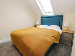a bedroom with a large bed with a blue headboard at Bears Court The Flat in Cheltenham
