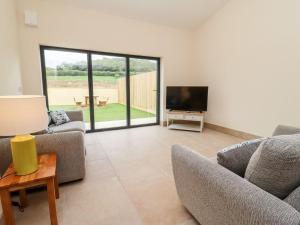 a living room with two couches and a flat screen tv at Bears Court Barn 3 in Cheltenham