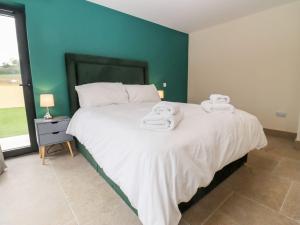 a bedroom with a bed with towels on it at Bears Court Barn 3 in Cheltenham