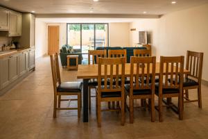 a kitchen and dining room with a wooden table and chairs at Bears Court Barn 6 in Cheltenham +18 photos