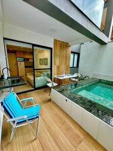 a room with a pool and a chair and a tub at Melhor localização Porto Galinhas 50M DO MAR E CENTRINHO - COM E SEM PISCINA PRIVATIVA Family Flats Porto de Galinhas in Porto De Galinhas