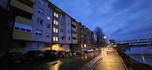 a city street with cars parked next to a building at Apartman River - stan na dan Gradiška in Bosanska Gradiška