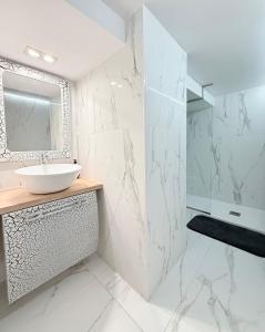 une salle de bain blanche avec un lavabo et un miroir dans l'établissement Riad-Entreplanta 2, à Melilla