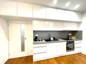 a kitchen with white cabinets and a sink at Matis 3 - Apartmán Brno centrum in Brno