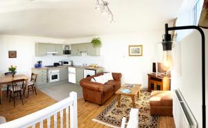 a living room and kitchen with a couch and a table at Number Three The Old Drill Hall in Sturminster Newton