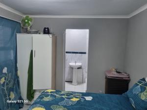 a bedroom with a bed and a bathroom with a sink at 27 on Milton in Cape Town