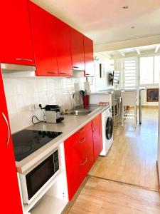 cocina con armarios rojos y comedor en Hibiscus Duplex Port Marina, en Saint-François