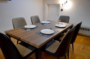 a wooden table with chairs and plates and glasses on it at Wooden Attic in Kastoria +14 photos