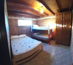 a small room with a bed and a bunk bed at Complejo Cuarto Menguante in Arroyo de Los Patos