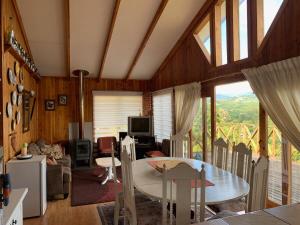 a living room with a table and a large window at Cabaña Licanray, vista volcán Villarrica y lago Calafquén in Licán Ray +9 photos