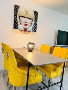 a dining room with a table and yellow chairs at Tarbey - Studio au départ du télécabine Torrent in Leukerbad +10 photos
