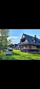 a large house with a car parked in front of it at Domki Siychlanski Potok in Murzasichle +12 photos