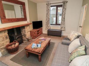 een woonkamer met een bank en een open haard bij Providence Cottage in Whitby