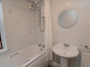 een badkamer met een wastafel, een bad, een toilet en een spiegel bij Providence Cottage in Whitby +16 foto's