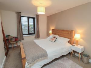 een slaapkamer met een groot bed en een raam bij Providence Cottage in Whitby