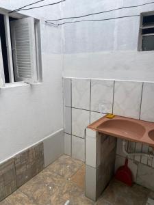 Baño pequeño con mesa y ventana en Casa em vila familiar, en Natal