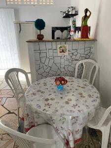 una mesa y sillas blancas con una mesa y una mesa y una mesa con sillas en Casa em vila familiar, en Natal