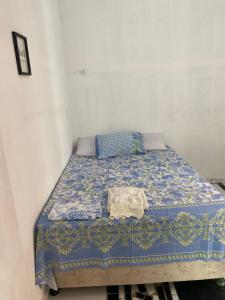 Cama en habitación blanca con edredón azul en Casa em vila familiar, en Natal