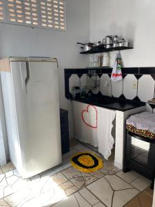 Una cocina con un refrigerador blanco y una encimera. en Casa em vila familiar, en Natal 3 fotos más