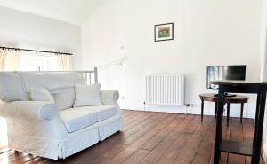 a living room with a white couch and a table at Number Three The Old Drill Hall in Sturminster Newton