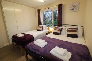 zwei Einzelbetten in einem Zimmer mit Fenster in der Unterkunft Keswick House Chesterfield by Smart Corporate Stays in Newbold