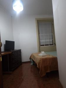Cette chambre comprend un lit, une télévision et une fenêtre. dans l'établissement Truz truz2, à Porto