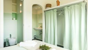 bagno con tenda per la doccia e servizi igienici di Sardegna è - Beach Apartments a Olbia