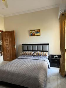 a bedroom with a large bed with a black headboard at 2 Bedroom Spacious Apartment in Islamabad in Islamabad