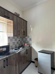 a kitchen with wooden cabinets and a white refrigerator at 2 Bedroom Spacious Apartment in Islamabad in Islamabad