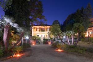 a building with palm trees in front of it at night at Affittacamere Villa Gigli in Sirolo