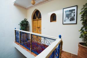 a staircase with a blue and gold door at Riad Dar Kella in Marrakech