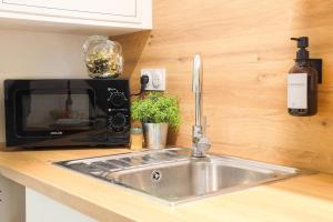 a kitchen counter with a sink and a microwave at Souplex - Centre - Terrasse - Clim in Valence