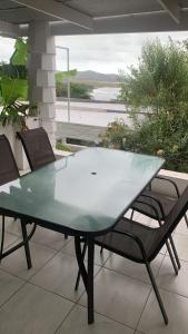 a glass table and chairs on a patio at Knysna Nature's View in Knysna