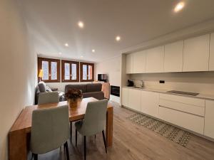 a kitchen and living room with a table and chairs at BPirineos-La Solana in Benasque