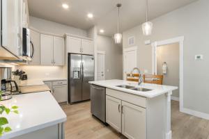 a kitchen with white cabinets and a stainless steel refrigerator at NOCO Retreat with King Beds, Fireplace, Scenic Trails in Loveland