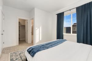 a white bedroom with a bed and a window at NOCO Retreat with King Beds, Fireplace, Scenic Trails in Loveland +30 photos