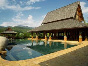 a house with a pool in front of a building at Howie's HomeStay in Mae Rim