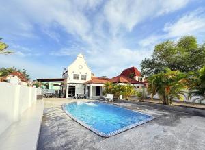 a house with a swimming pool in front of a house at Pool Villa 833 - Fong Homestay in Kampong Alor Gajah