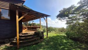a cabin with a porch and stairs to a house at Casa Cabuya - Retro Style with Gulf View in Monteverde in Monteverde Costa Rica