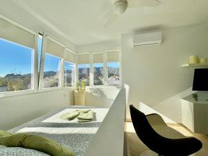 Un dormitorio blanco con una cama y una silla. en Green Hill 435, en Torremolinos