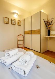 a bedroom with two white towels on a bed at HELIOS ApArt Hotel - DeLuxe Residence, close to the city CENTER in Timişoara